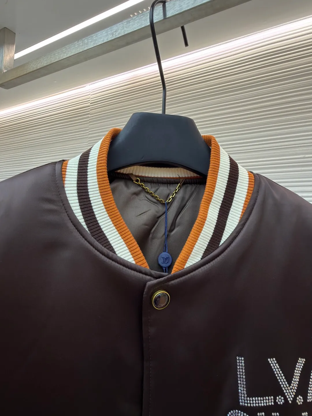 LOUIS VUITTON decorative flight jacket ●Original version: 30,000 purchased and developed ●Item number: 1682285-B90 ●Fabric: cotton fabric ●Technology: patch production ●Color: brown ●Version: fitted version ●Weight: about 1085 grams ●Size: 46-48-50-52 ●Description: The main body of this Louis Vuitton satin baseball jacket is made of high-density matte satin fabric, which has been treated with anti-wrinkle shaping technology. The fabric has a strong drape and is not easy to wrinkle. The dark brown background color is prepared by precision dyeing and finishing technology, giving it a rich color and high-end texture. The "L.V.M SINCE 1854" logo on the left chest is made with hot-drilling technology. High-quality rhinestones are used for precise hot-pasting in different areas. The diamond surface is shiny and strong and will not fall off easily. The ribbed splicing of the collar, cuffs and hem is a three-color contrasting design. It is woven with high-elastic knitted yarn, which will not easily loosen and deform after long-term wear. The placket is equipped with custom-made metal snaps. The hardware is thick and anti-oxidation. The overall style is loose and off-shoulder. The splicing is covered with blind stitching technology, and the wiring is smooth and traceless. Every craft detail follows the brand's luxury product production standards, taking into account both design and wearing comfort. The overall wiring is straight and delicate, the fabric is comfortable and soft, and the color is consistent without color difference. It can be matched with the same style to create a fashionable look and control various occasions. Customized accessories, complete with three standards, same style for men and women!